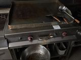 une casserole et une poêle posées sur une cuisinière dans une cuisine