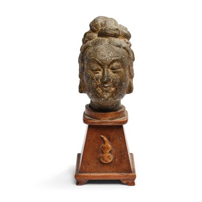 une image représentant la tête d'une femme sculptée sur un socle en bois