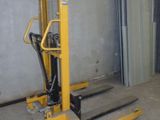 un chariot élévateur jaune garé devant un immeuble