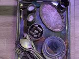 a silver tray with silverware and spoons on it