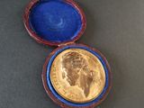 a gold coin in a blue case on a table