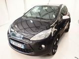 une voiture noire garée dans une pièce blanche