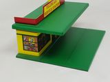 a small green and yellow building with a sign on it