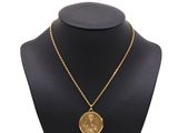 un collier en or avec une pièce de monnaie sur le cou d'un mannequin