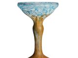 un saladier en verre posé sur un socle en bois, sur fond blanc