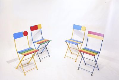 une paire de chaises pliantes colorées sur fond blanc dans un studio