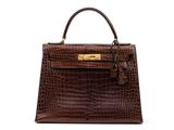 a brown crocodile skin handbag on a white background