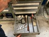 un homme qui regarde des outils dans un tiroir