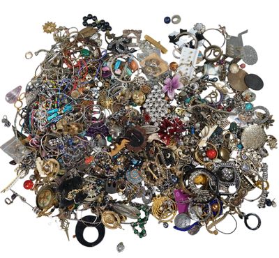 a pile of assorted jewelry on a white surface