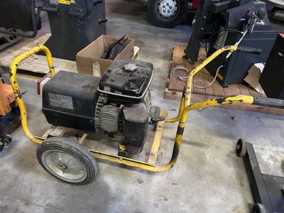 a man working on a small engine in a garage