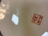 a close up of a plate with a red stamp on it