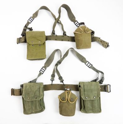 three military pouchs and a pair of scissors hanging on a wall