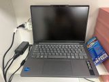 an open laptop computer sitting on top of a desk next to a charger