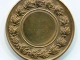 une assiette en or ornée d'une couronne de feuilles et de baies