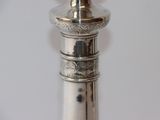 a silver candle that is on top of a metal pole