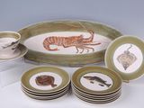 many plates and cups on the table with a picture of a lobster on them