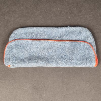 un gros plan d'un étui gris et orange posé sur une surface marron
