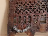 a wooden bench with carvings on it in a room