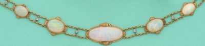 une image représentant un collier en or orné d'oplites sur fond turquoise