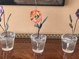 three vases that have flowers in them on a table