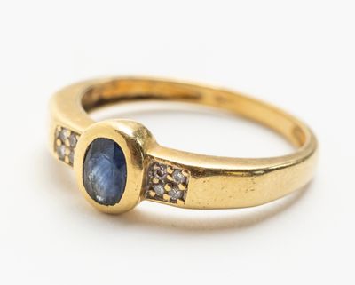 Gros plan sur une bague en or ornée d'un saphir bleu