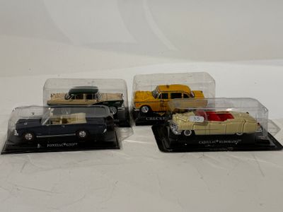 trois petites voitures dans une vitrine posée sur une surface blanche
