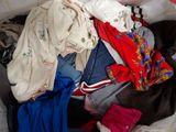 a pile of clothes in a suitcase on the floor