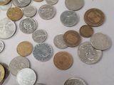 a pile of coins sitting on a table next to a calculator