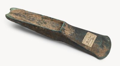 un vieux couteau au manche en bois posé sur une surface blanche