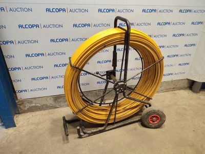 an image of a yellow hose is on a cart in front of a wall