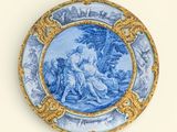 une assiette bleue et dorée ornée d'une peinture