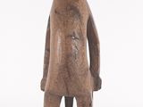 wooden statue of a man with a hat on his head and hands on his hips
