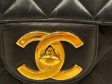 a close up of a black and gold chanel bag
