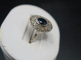 silver ring with blue stone on top of a white box