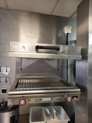 un grand grill en acier inoxydable dans la cuisine, avec ses ustensiles