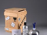 a small wooden box with a bottle of alcohol next to it