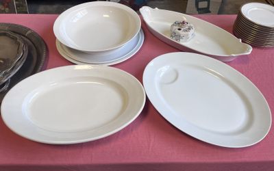 de nombreuses assiettes et bols posés sur une table recouverte d'une nappe rose