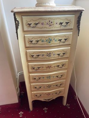 a white vase on top of a chest of drawers