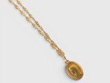 a gold necklace with a coin on a gold chain