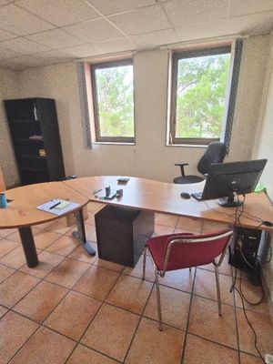 une pièce équipée d'une table, de chaises et d'un réfrigérateur