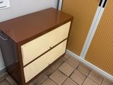 a brown and white chest of drawers in the corner of a room