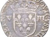 a close up of a silver coin with a crown on it