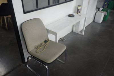 une chaise et une table dans une pièce où est accroché un tableau au mur