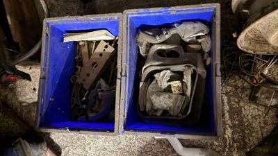 deux boîtes bleues remplies d'objets divers, posées par terre