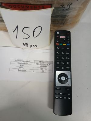une télécommande posée sur une table à côté d'un sac de nourriture