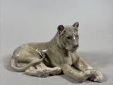 a porcelain figurine of a dog laying down on the ground