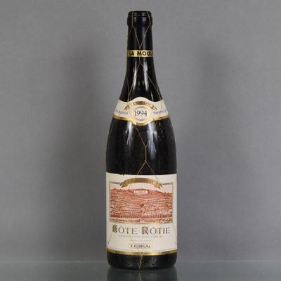 une vieille bouteille de vin posée sur une table en verre