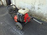 a red and black lawn mower sitting on the ground