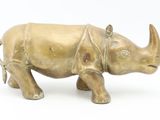 a bronze statue of a rhino on a white background