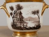 a vase with a picture of a house on it on a table